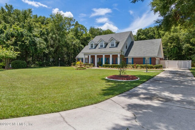 cape cod home featuring a front yard