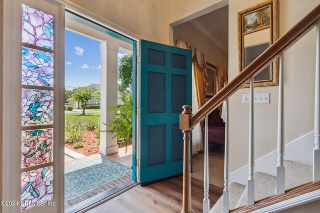 entrance foyer with ornamental molding and hardwood / wood-style flooring