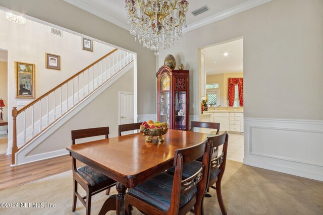 dining room featuring crown molding, a chandelier, and light hardwood / wood-style flooring