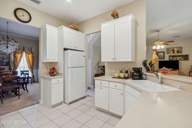 kitchen with white refrigerator, white cabinetry, sink, and light colored carpet