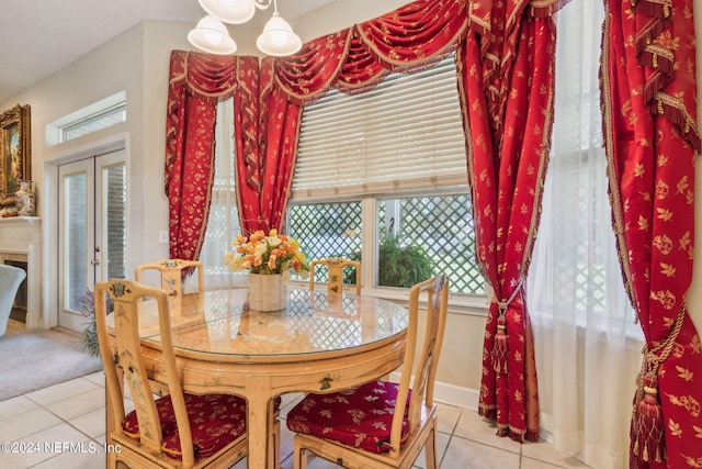 dining area featuring an inviting chandelier, french doors, and light tile patterned floors