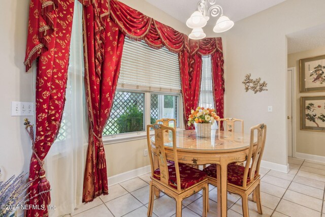 tiled dining space with a chandelier