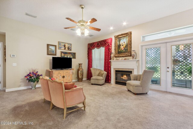 carpeted living room with french doors, a tile fireplace, and ceiling fan