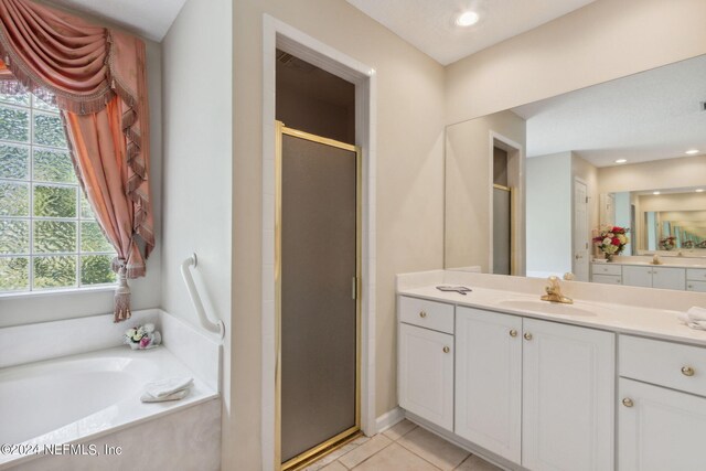 bathroom with vanity, plus walk in shower, and tile patterned flooring