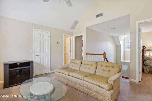 carpeted living room with ceiling fan and vaulted ceiling