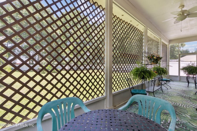 unfurnished sunroom featuring ceiling fan