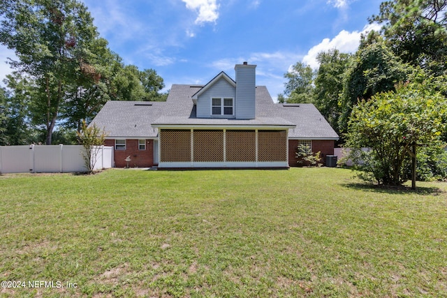 rear view of property featuring a lawn