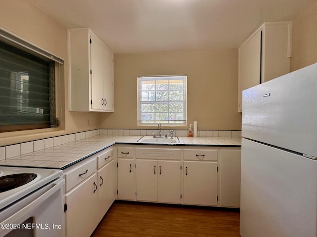 kitchen with white appliances, dark wood-type flooring, white cabinetry, sink, and tile countertops