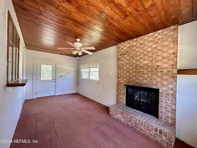 unfurnished living room featuring carpet, a healthy amount of sunlight, a brick fireplace, and ceiling fan