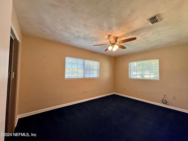 unfurnished room with ceiling fan, a healthy amount of sunlight, and a textured ceiling