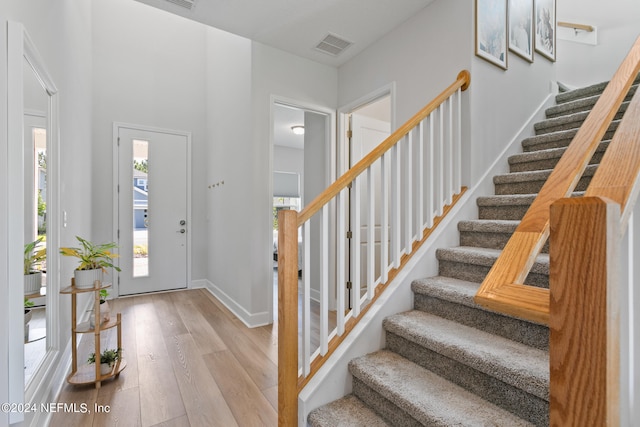 foyer featuring light hardwood / wood-style flooring and a towering ceiling