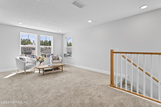 carpeted living room featuring a textured ceiling