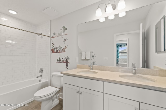 full bathroom featuring tiled shower / bath, toilet, and double sink vanity