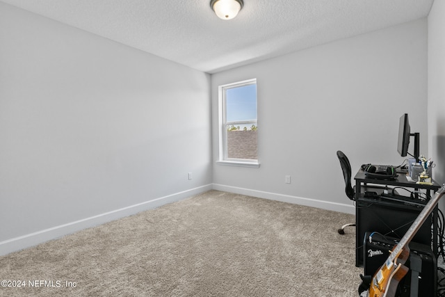 home office featuring carpet floors and a textured ceiling