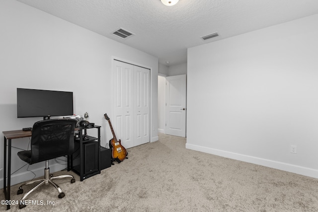 carpeted home office with a textured ceiling