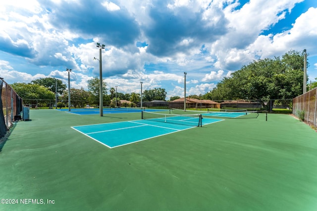 view of tennis court with basketball hoop