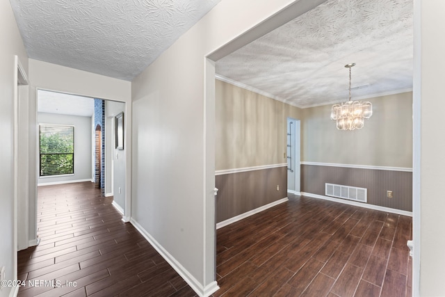 corridor featuring a textured ceiling and an inviting chandelier