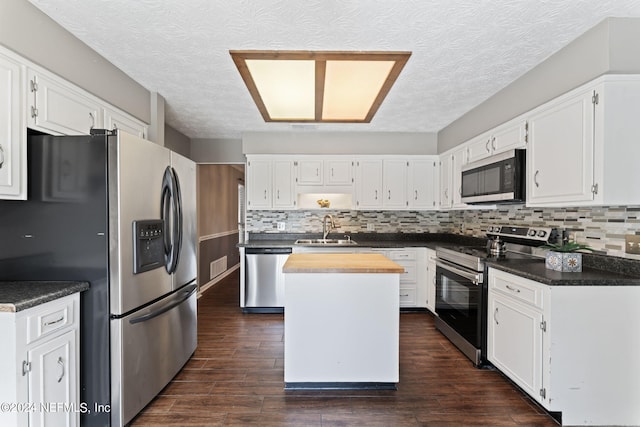 kitchen with a kitchen island, sink, white cabinetry, and stainless steel appliances