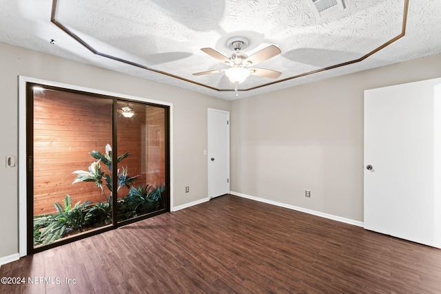 unfurnished room featuring ceiling fan, dark hardwood / wood-style flooring, and a textured ceiling