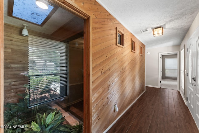 corridor with hardwood / wood-style floors and wood walls