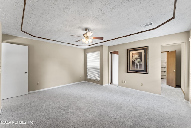 carpeted spare room featuring ceiling fan and a textured ceiling