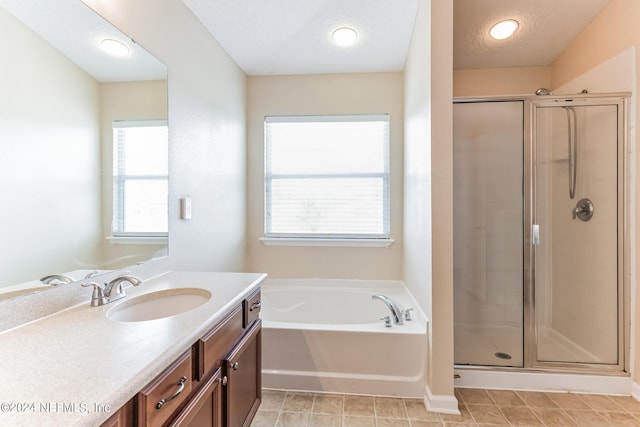 bathroom featuring independent shower and bath, a textured ceiling, and a healthy amount of sunlight