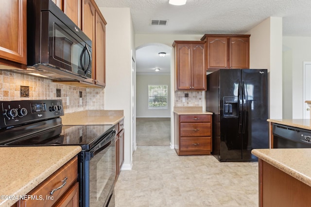 kitchen with black appliances, light stone counters, backsplash, and a textured ceiling