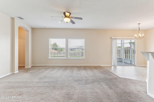 unfurnished living room featuring a textured ceiling, light carpet, and ceiling fan with notable chandelier