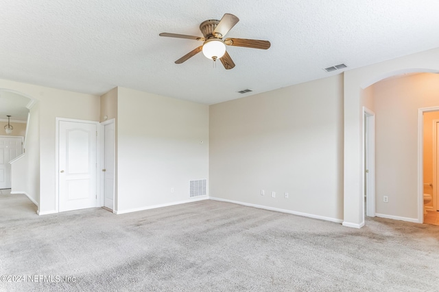 unfurnished room featuring a textured ceiling, light carpet, and ceiling fan