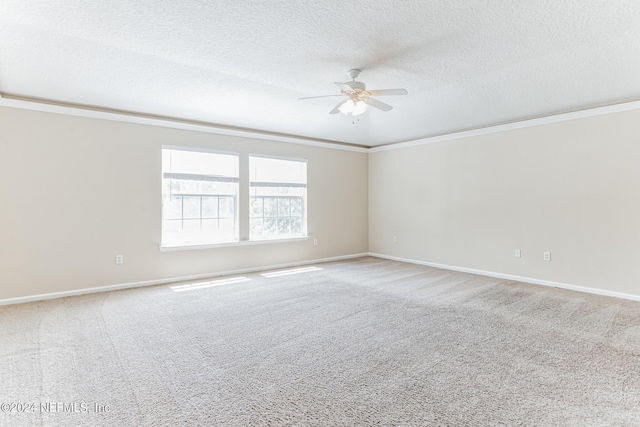 carpeted spare room featuring a textured ceiling, ceiling fan, and crown molding