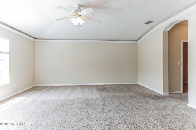 empty room featuring a textured ceiling, ceiling fan, crown molding, and carpet flooring