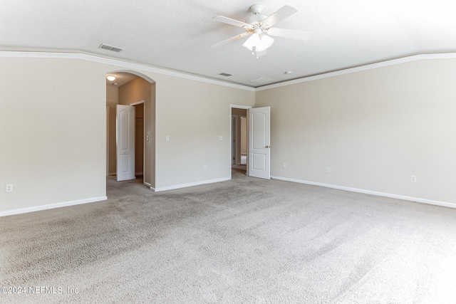 empty room featuring ceiling fan, light carpet, vaulted ceiling, and crown molding