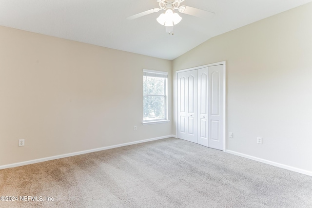 unfurnished bedroom featuring light carpet, a closet, ceiling fan, and vaulted ceiling