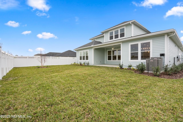 back of property with a patio area, a lawn, a fenced backyard, and ceiling fan