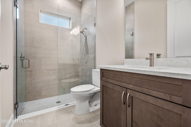 bathroom featuring tile patterned flooring, a stall shower, toilet, and vanity