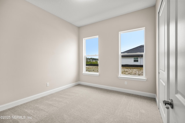 carpeted spare room with baseboards