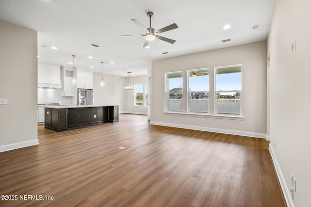 unfurnished living room with wood finished floors, baseboards, visible vents, recessed lighting, and ceiling fan