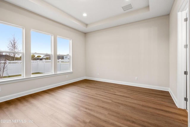 unfurnished room with recessed lighting, visible vents, baseboards, and wood finished floors