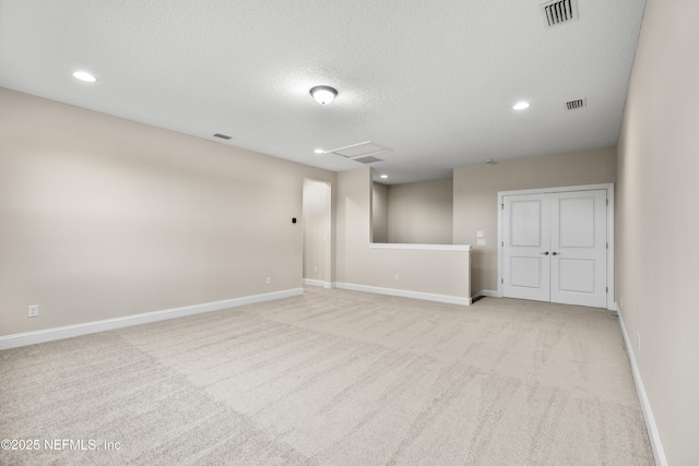 empty room with visible vents, light carpet, and baseboards