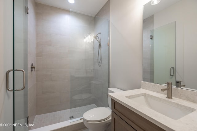 bathroom featuring vanity, toilet, and a shower stall