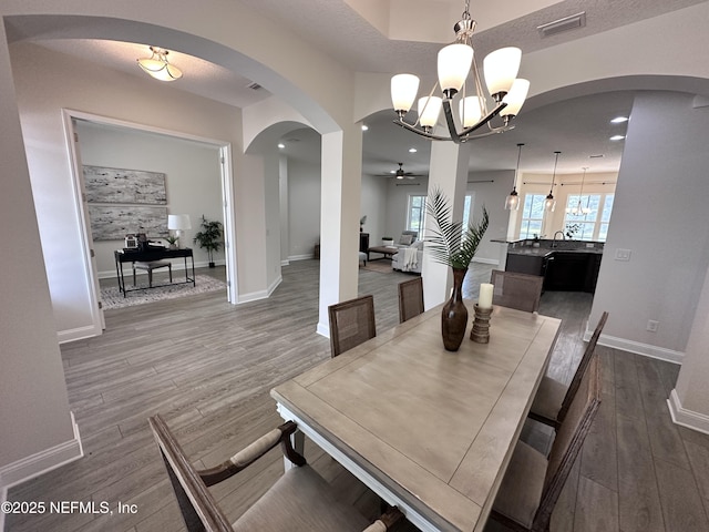 95014 Brookhill Pl, Fernandina Beach, FL 32034 - dining area featuring arched walkways, dark wood-style floors, a chandelier, a ceiling fan, and recessed lighting