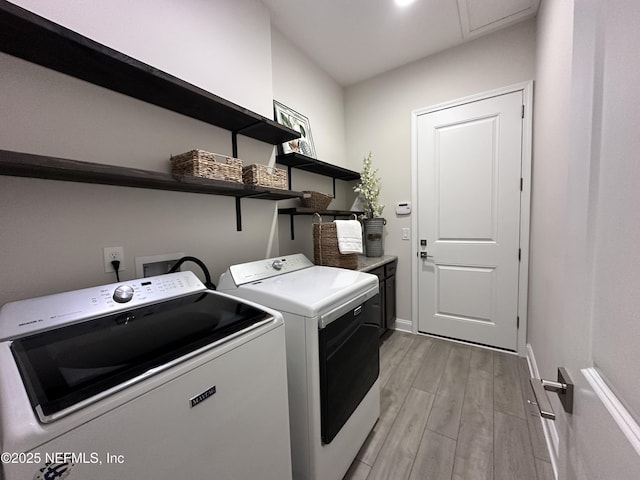 95014 Brookhill Pl, Fernandina Beach, FL 32034 - washroom featuring separate washer and dryer, light wood-type flooring, and cabinet space