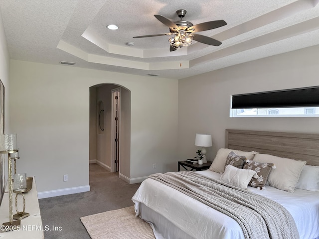 95014 Brookhill Pl, Fernandina Beach, FL 32034 - carpeted bedroom with arched walkways, a tray ceiling, a textured ceiling, and ceiling fan