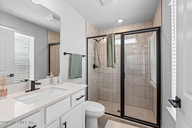 bathroom featuring vanity, an enclosed shower, and toilet