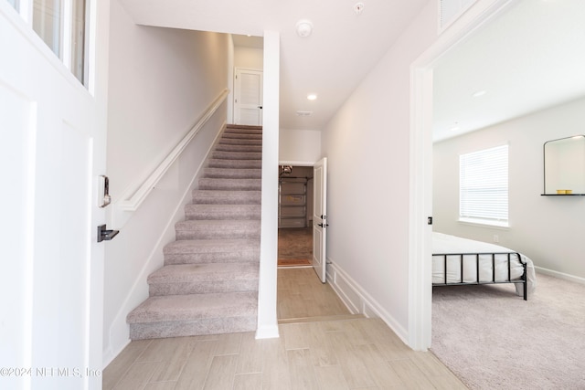 staircase featuring carpet flooring