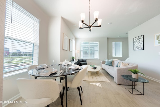 dining space featuring light hardwood / wood-style flooring and an inviting chandelier