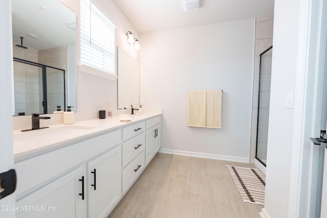 bathroom with vanity, hardwood / wood-style flooring, and a shower with shower door