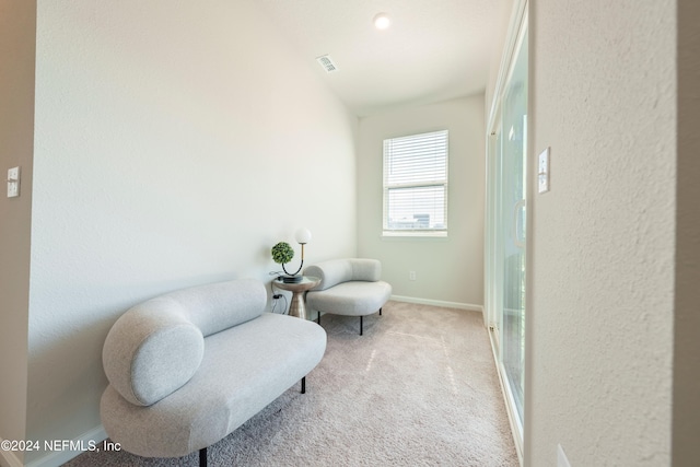 living area with lofted ceiling and light carpet