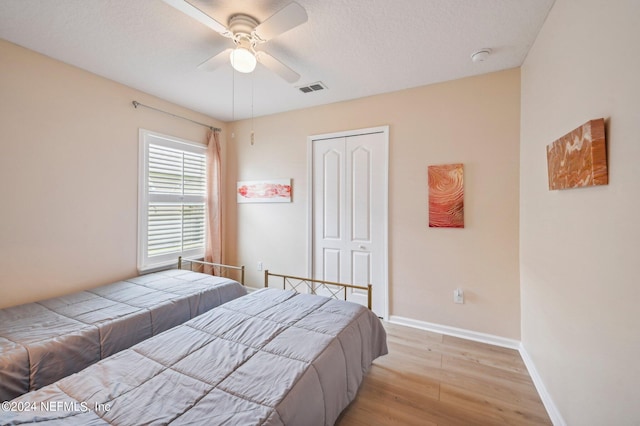 bedroom featuring ceiling fan, a closet, and light hardwood / wood-style floors