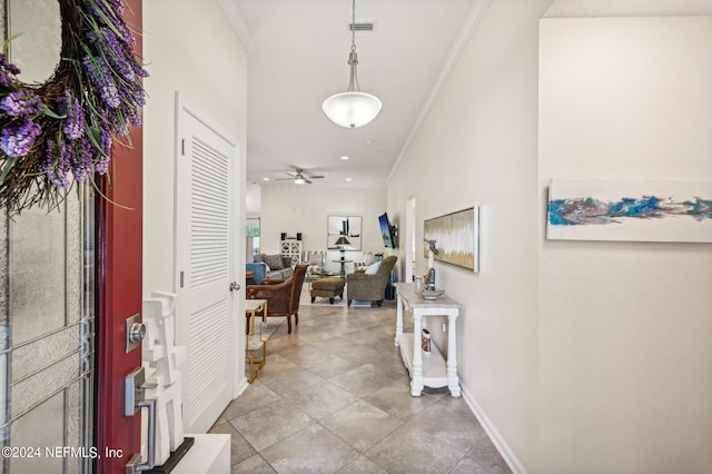 entryway featuring light tile patterned floors, ceiling fan, and crown molding